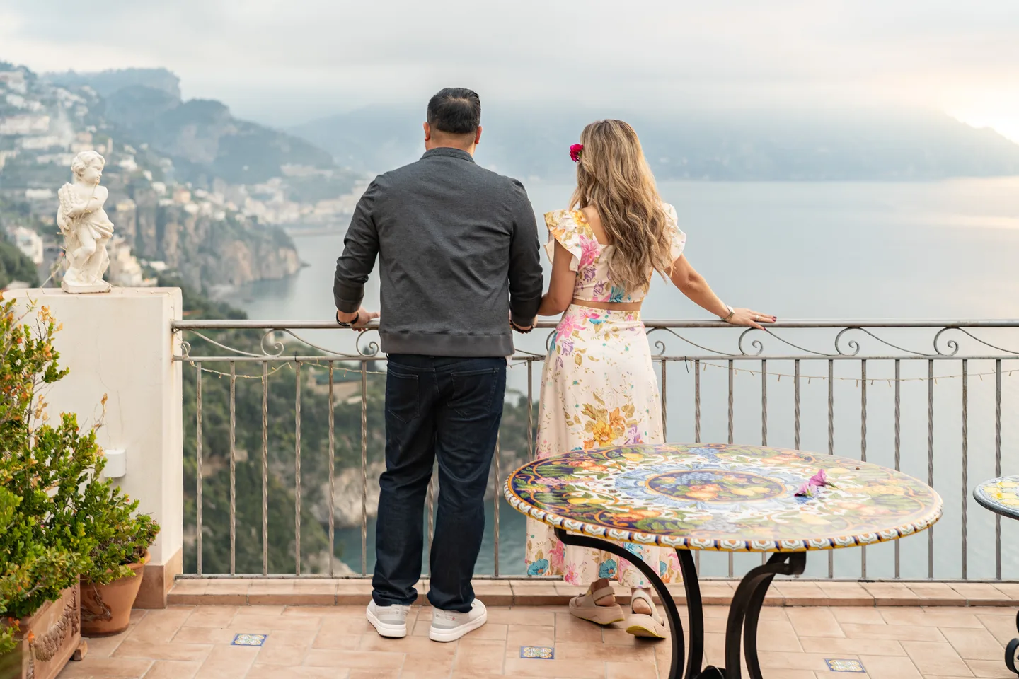 The couple looking out to sea beside the painted terrace table