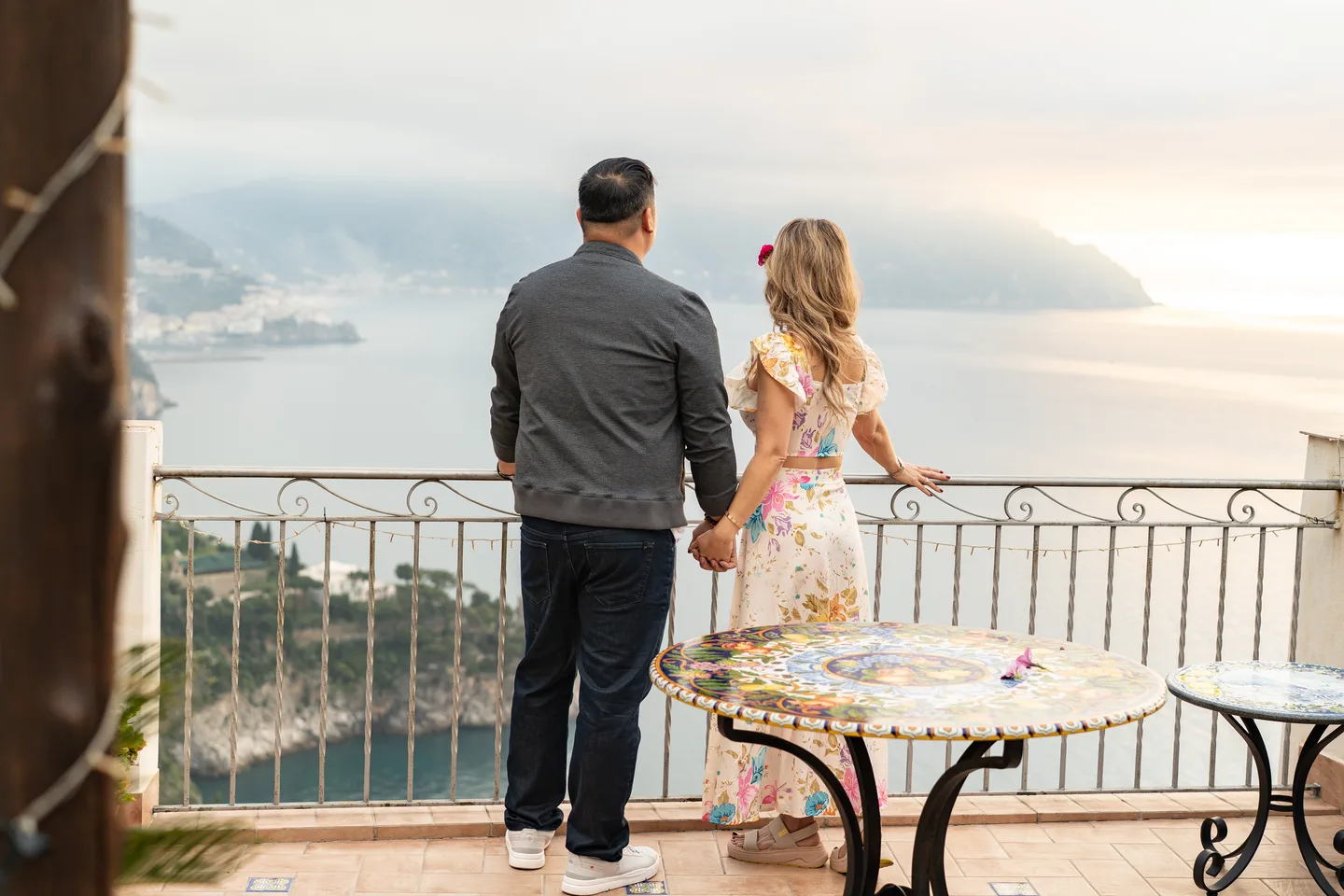 The couple on the terrace, framed by the villa doorway