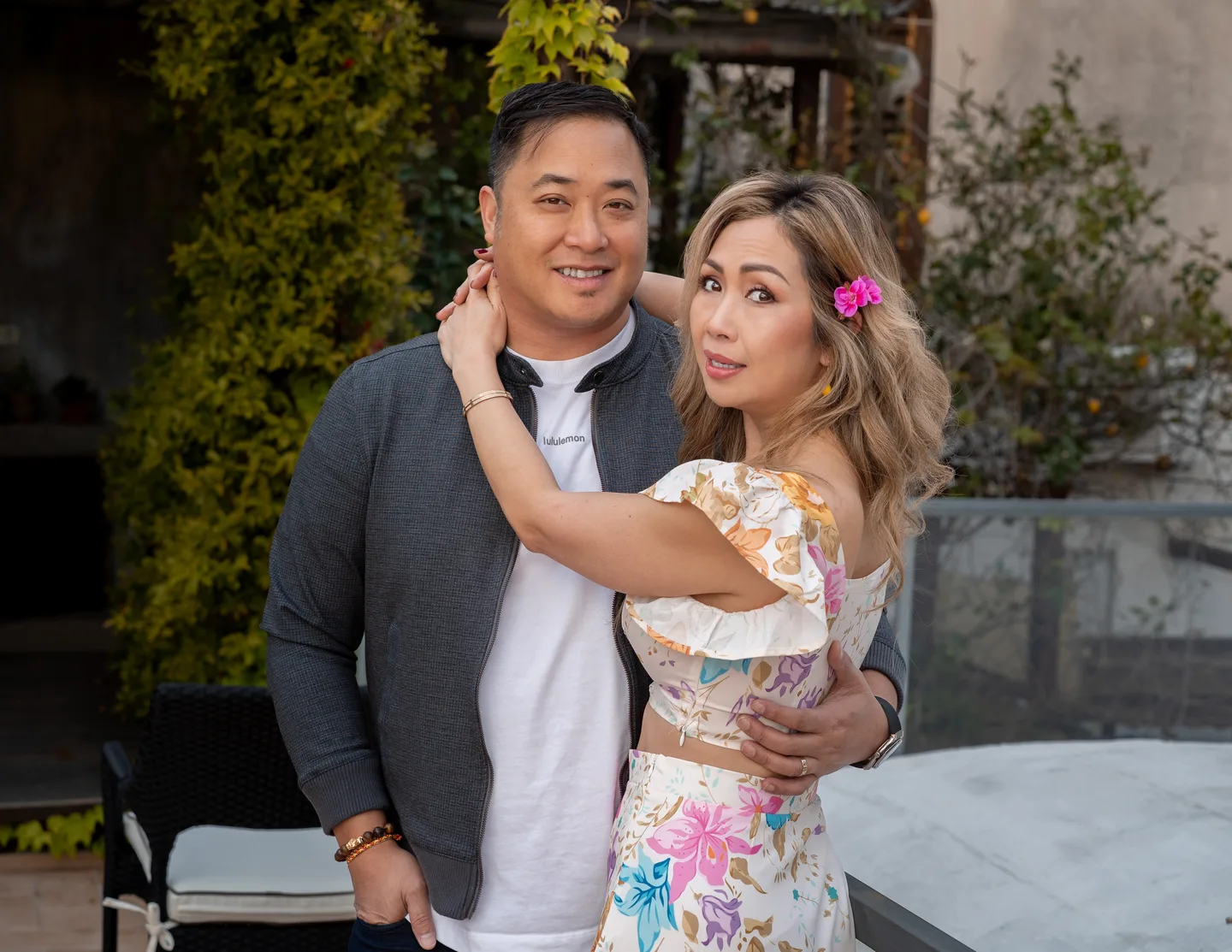 A portrait of the couple together by the terrace railing