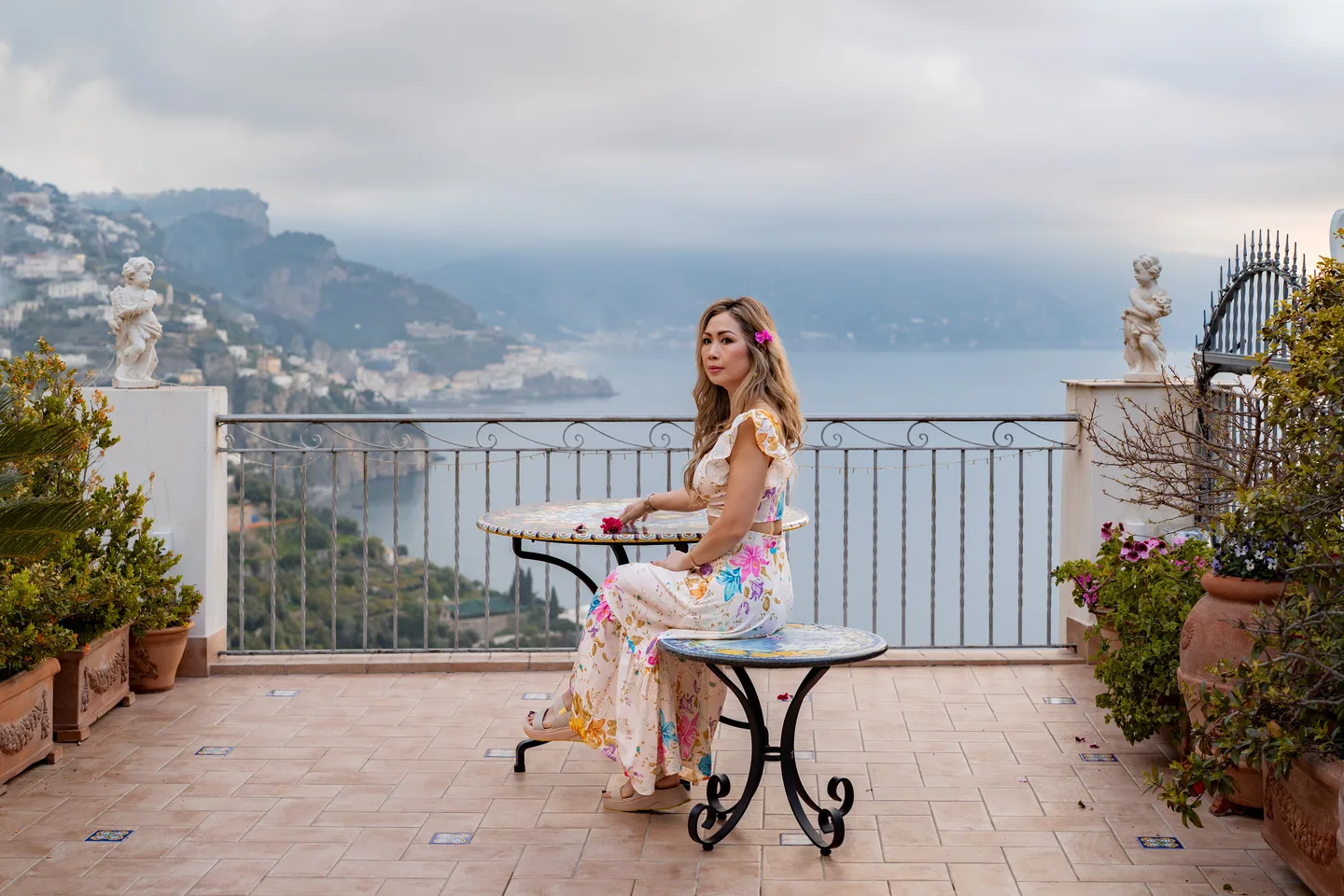 Anh seated at the painted table overlooking the coast