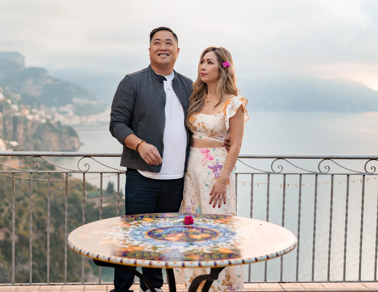 The couple laughing together behind the painted table