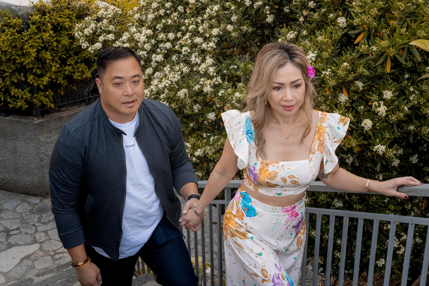 The couple holding hands as they climb the stone steps