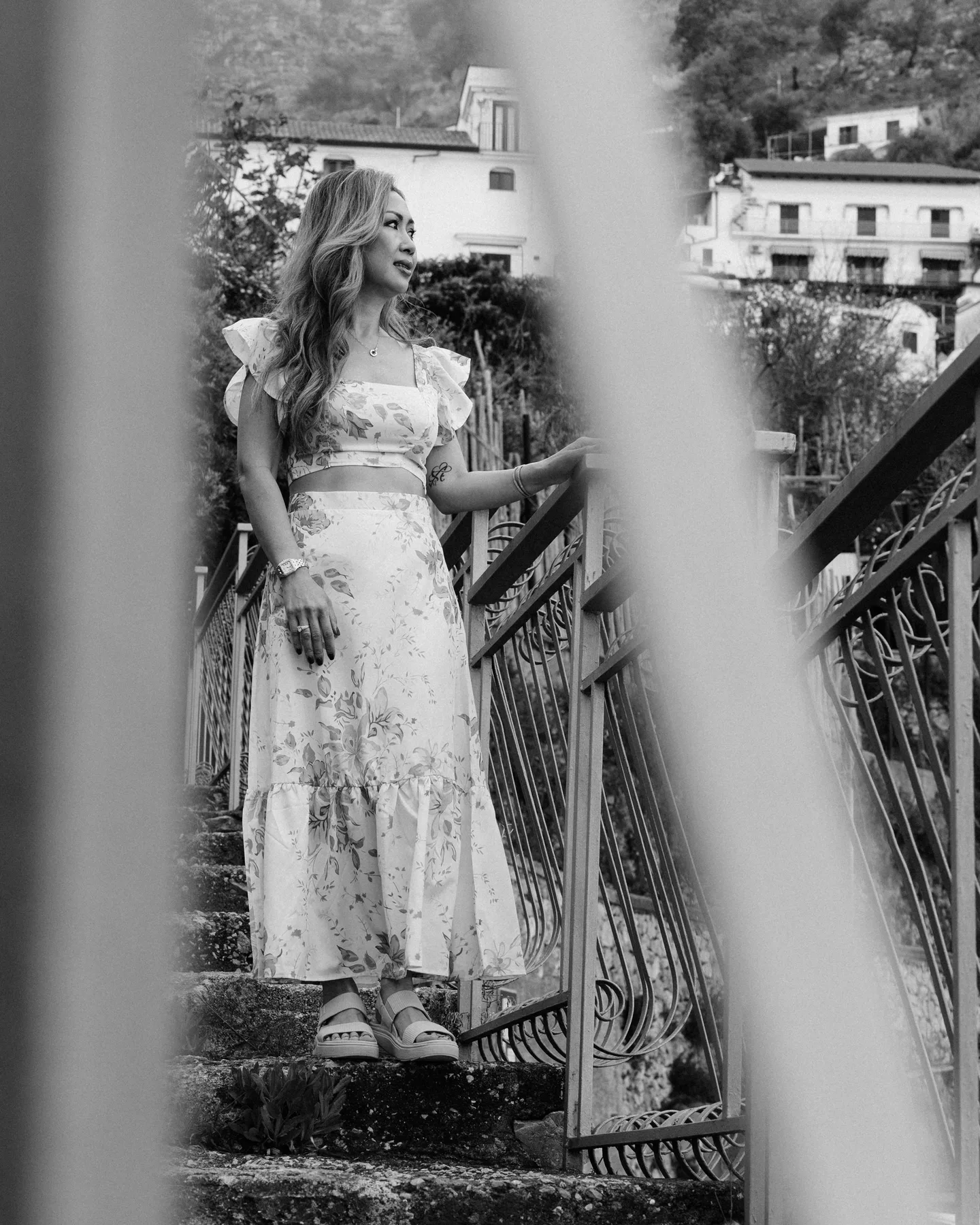 A black-and-white portrait of Anh through a staircase railing