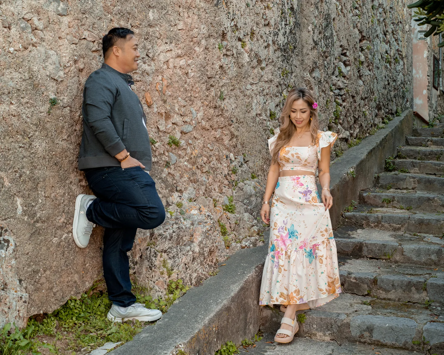 Anh on the steps with her companion leaning against the wall