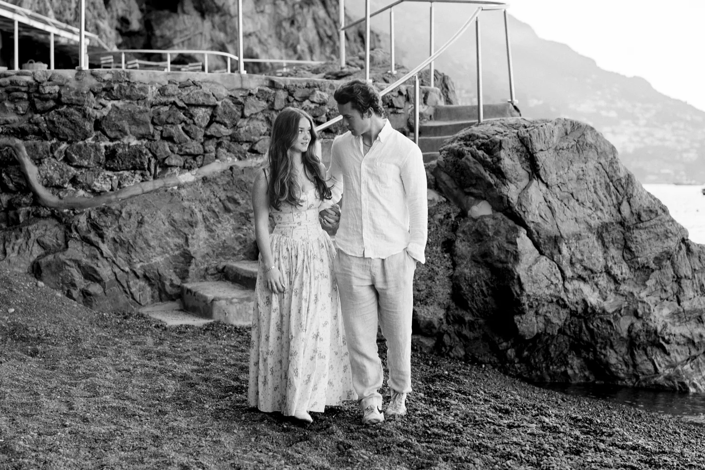 A black-and-white embrace by the beach steps