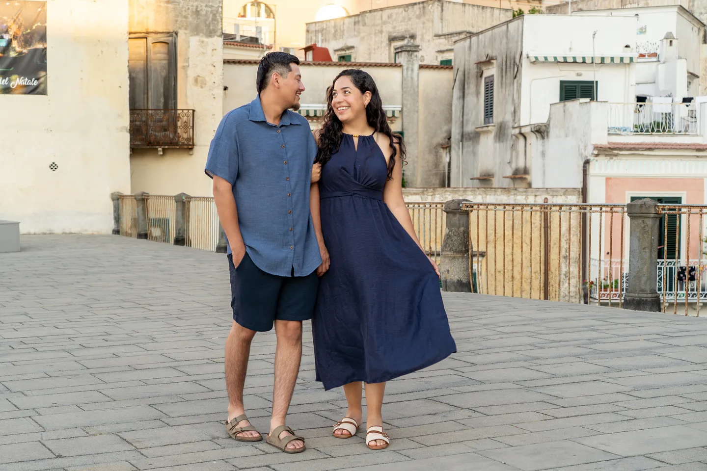 The couple laughing together beside the stone pavement