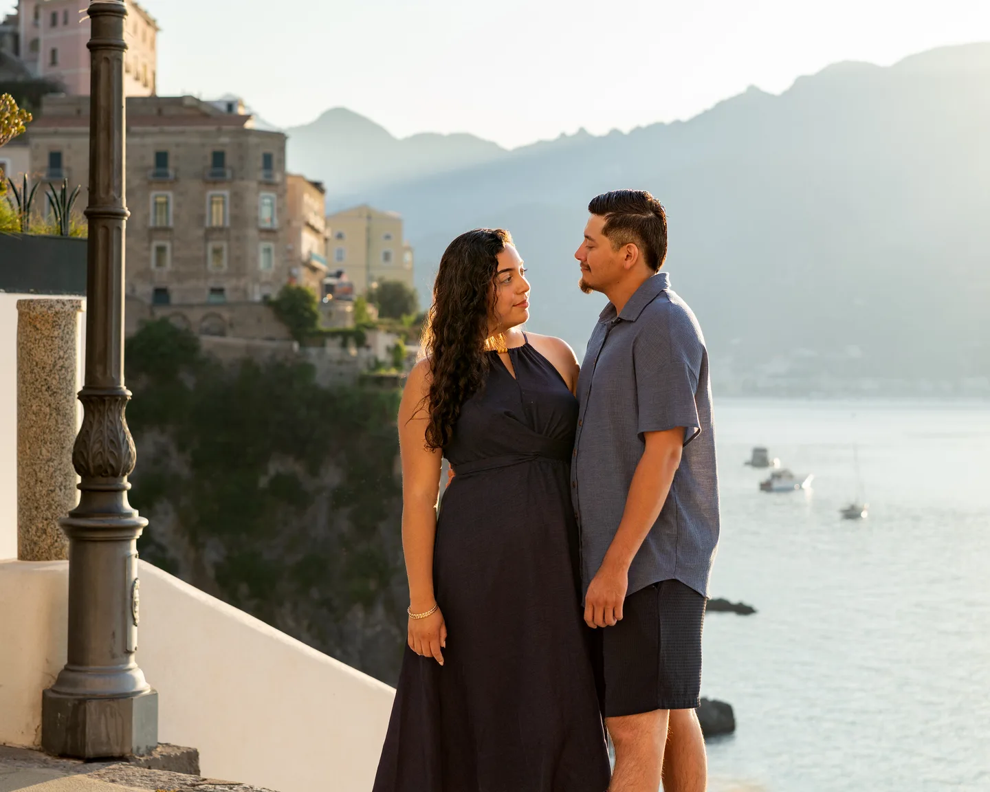 The couple looking at one another beside the white terrace wall