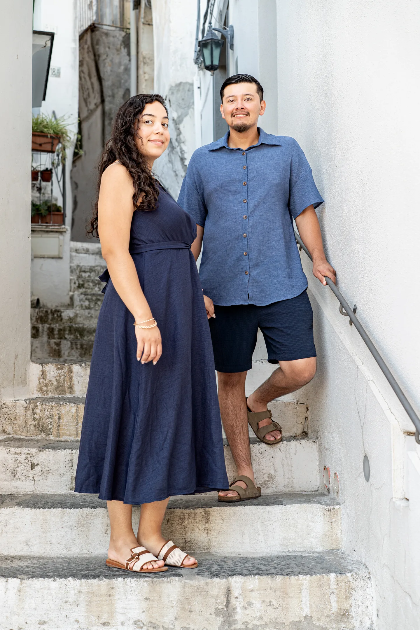 The couple standing on a narrow white staircase