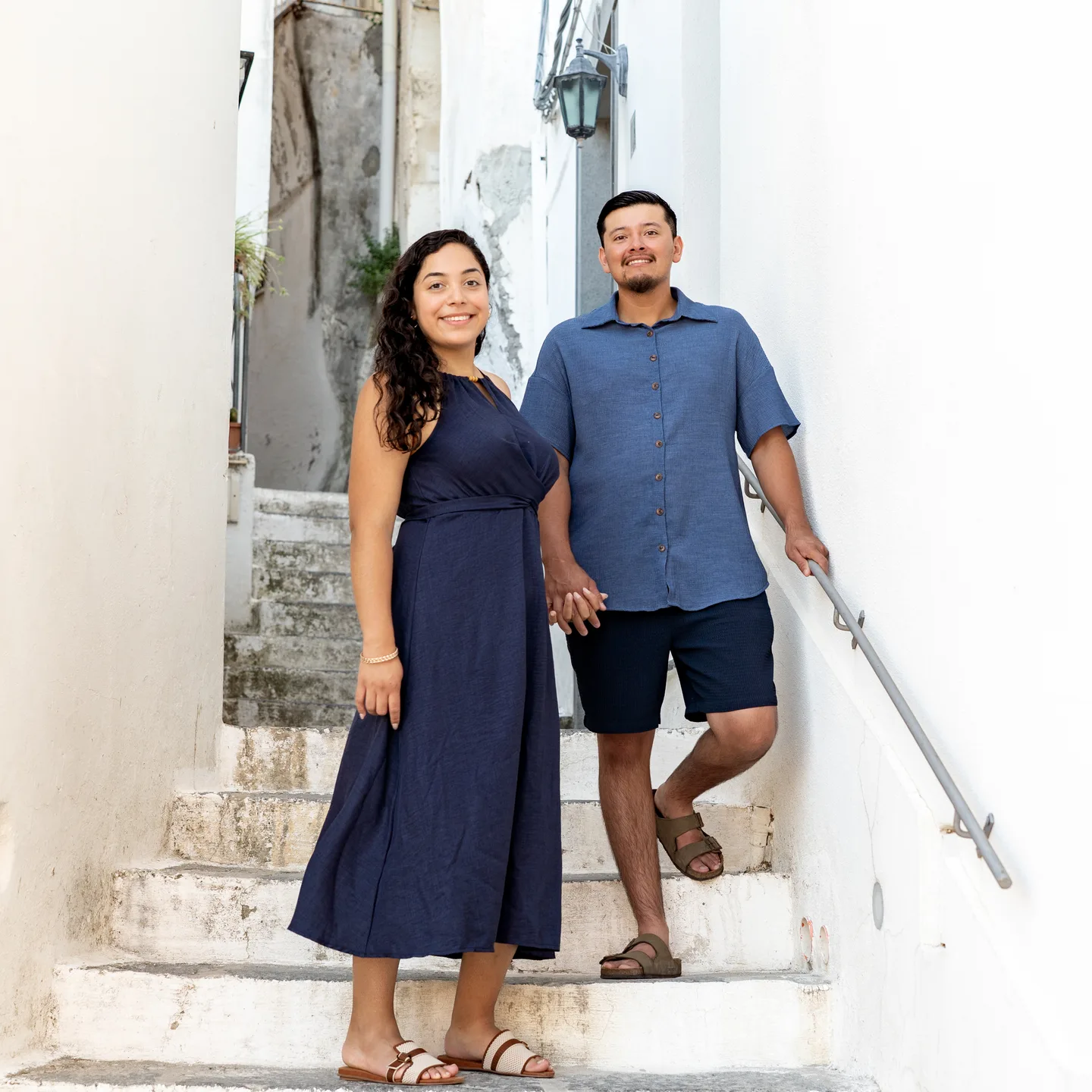 A full-length portrait of the couple on the white staircase