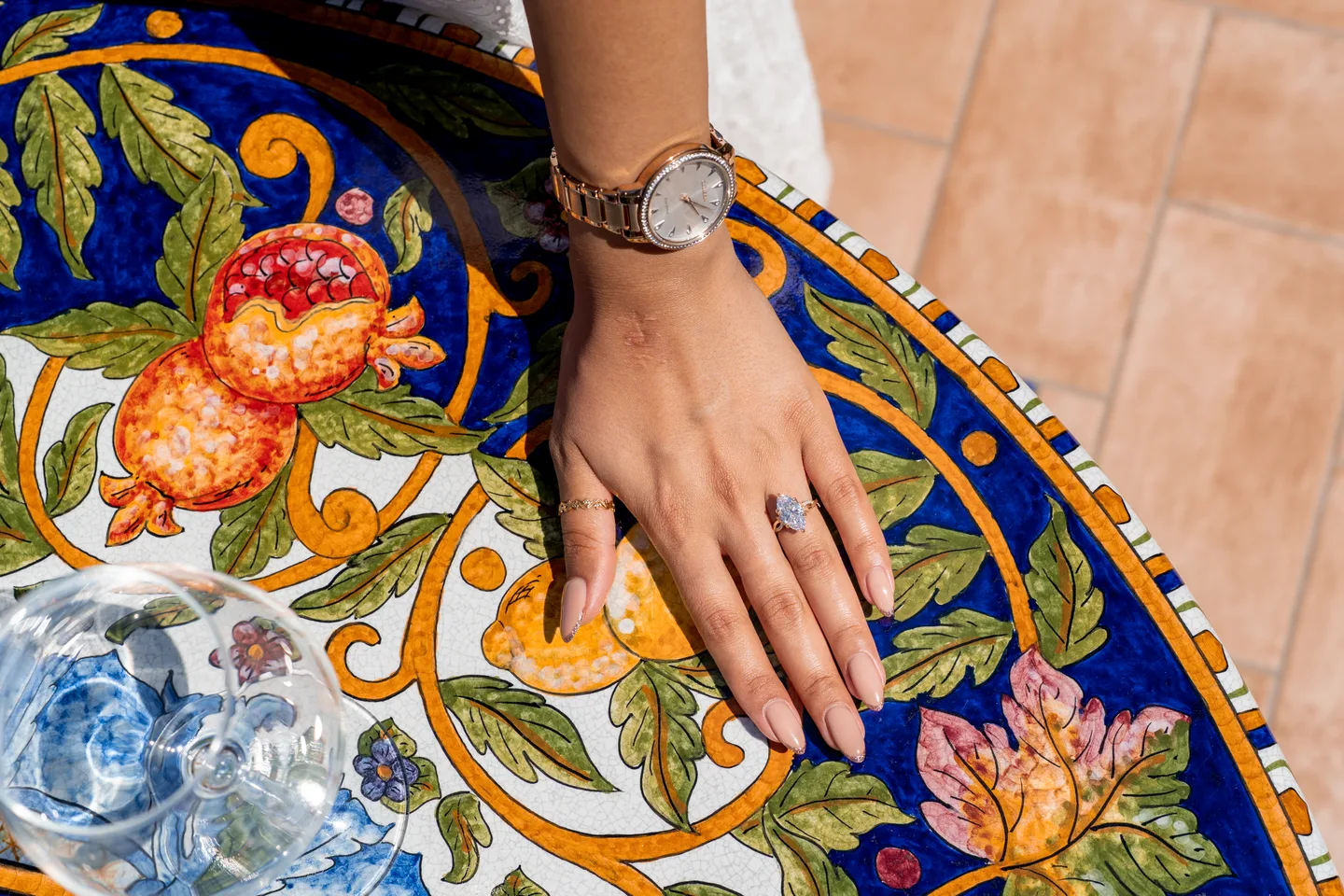 The engagement ring against a colourful ceramic table