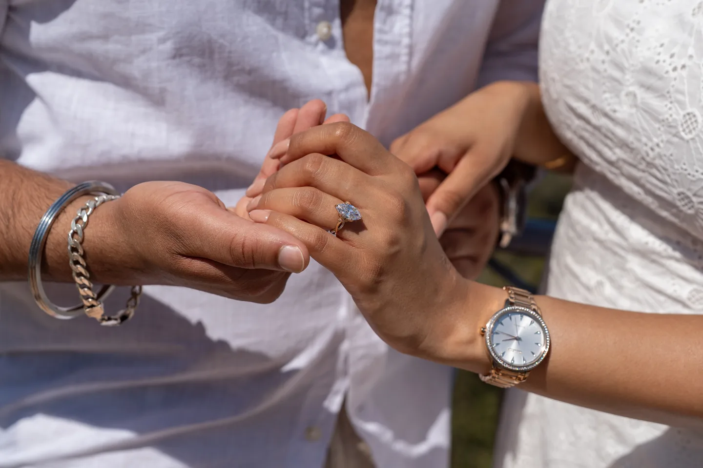 A close view of the engagement ring and joined hands