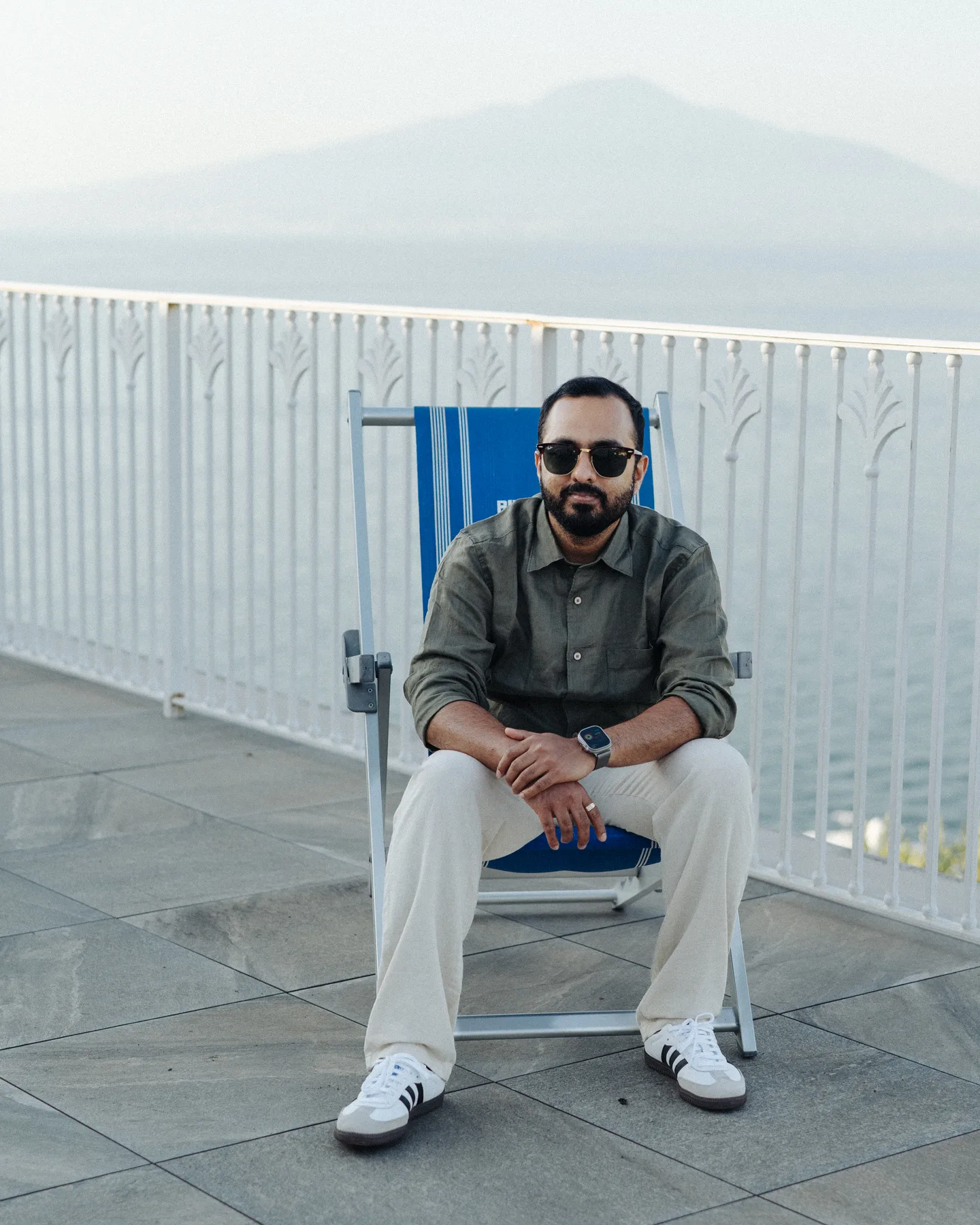 Jatin seated on a white chair above the sea