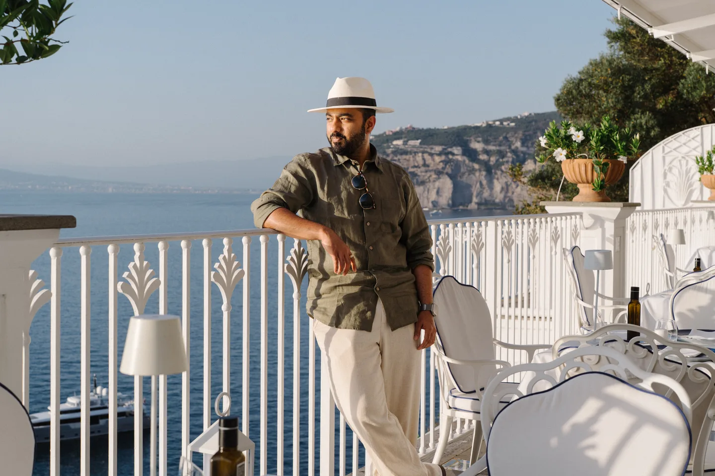 Jatin leaning on the terrace railing in his hat