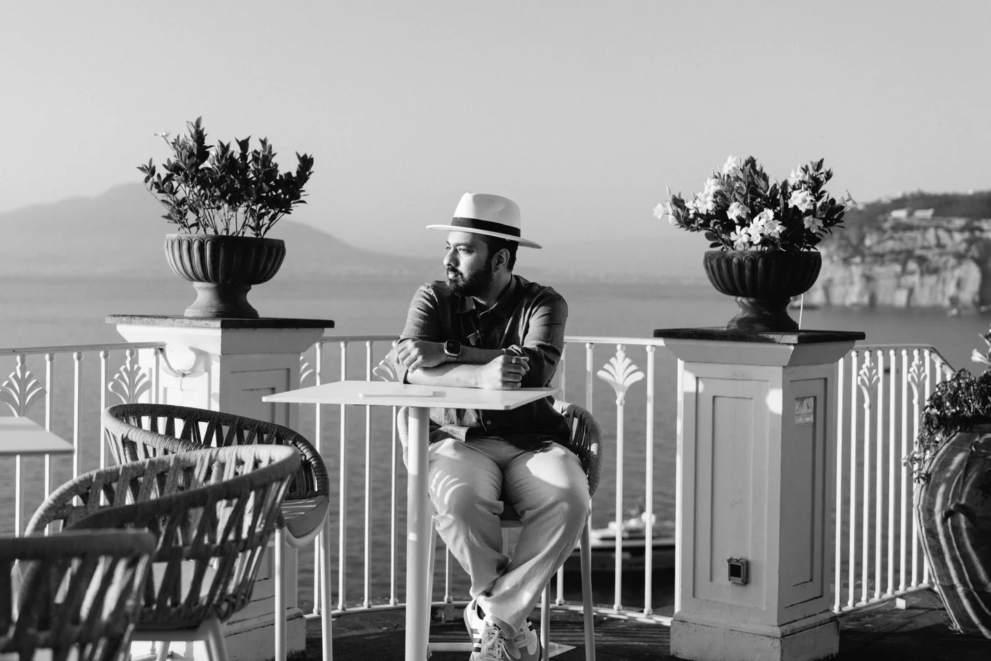 A black-and-white portrait of Jatin at a terrace table