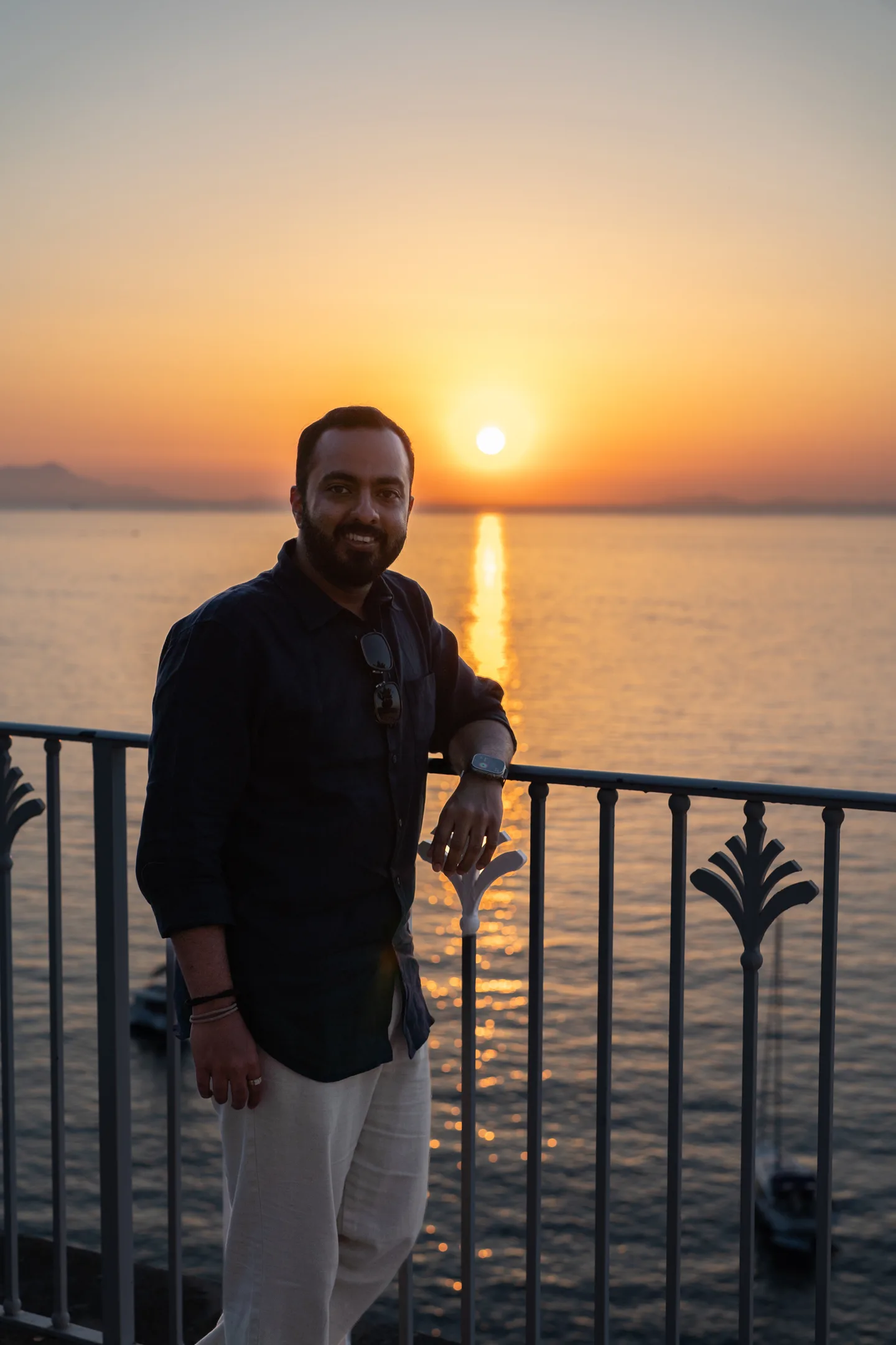 Jatin on the terrace with the sunset behind him
