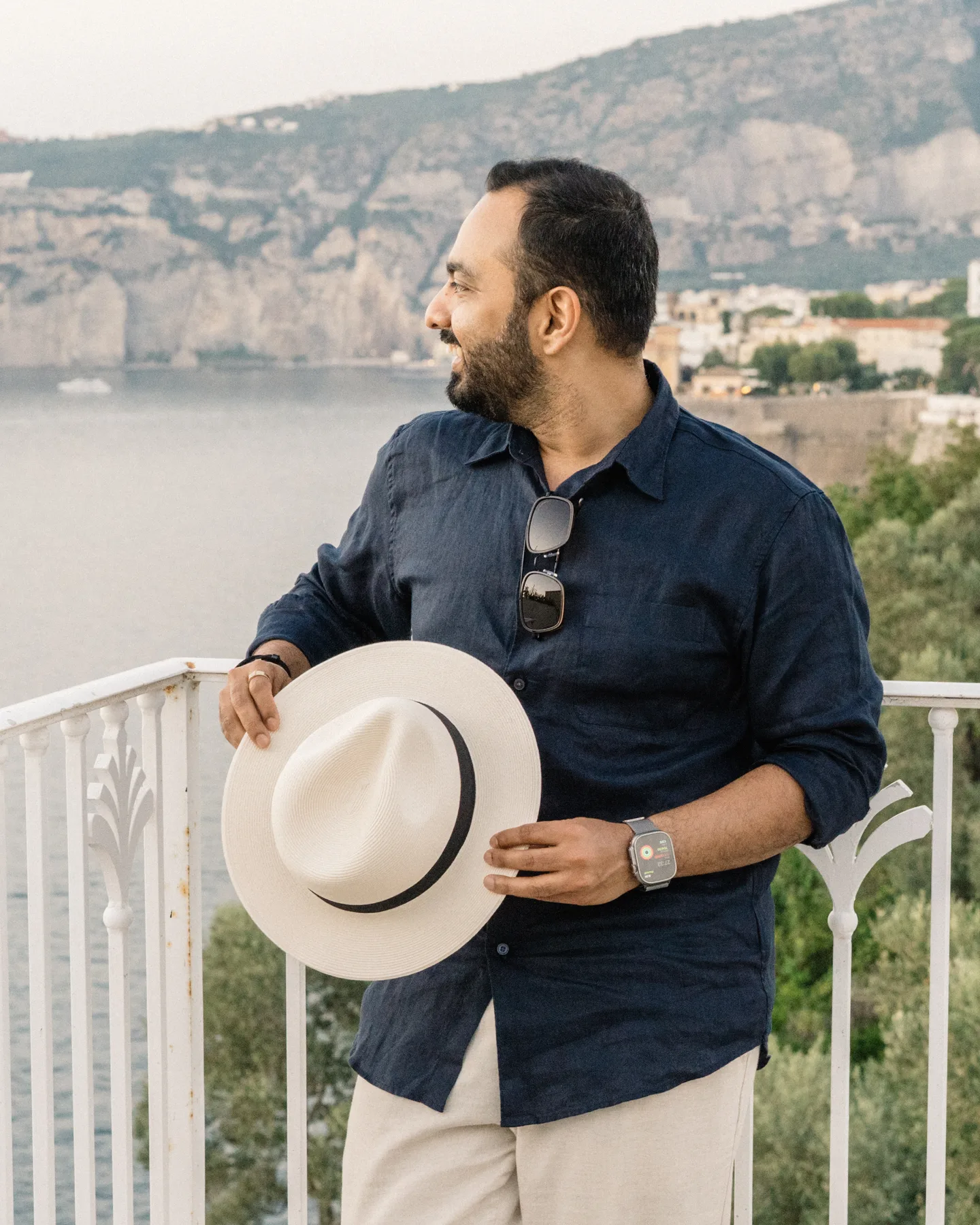 Jatin holding his hat and looking towards the town
