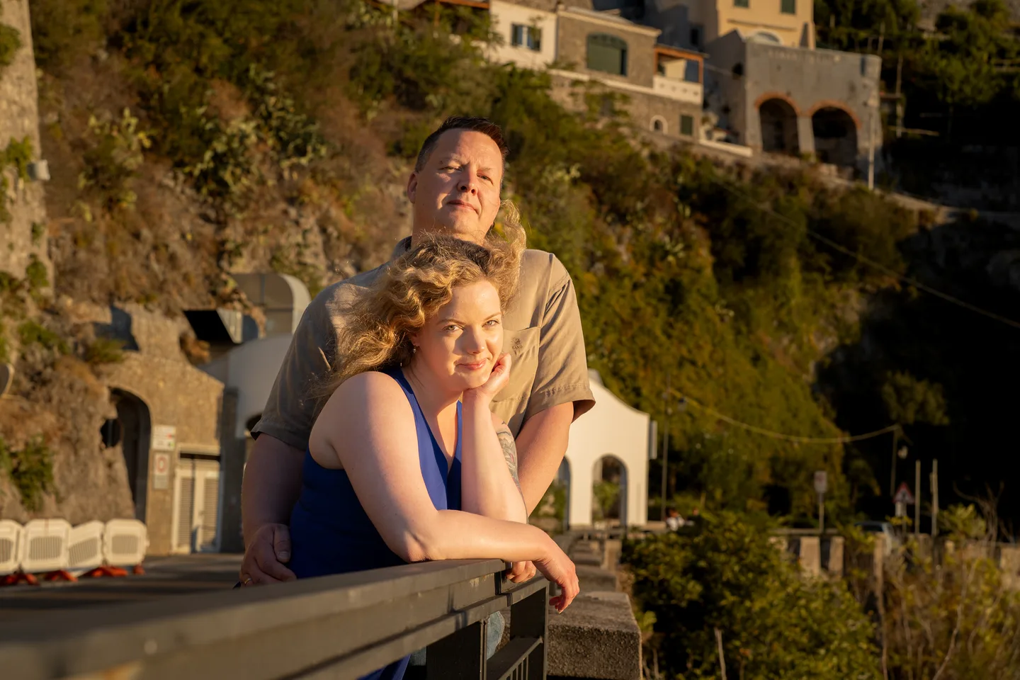 An embrace beside a stone railing