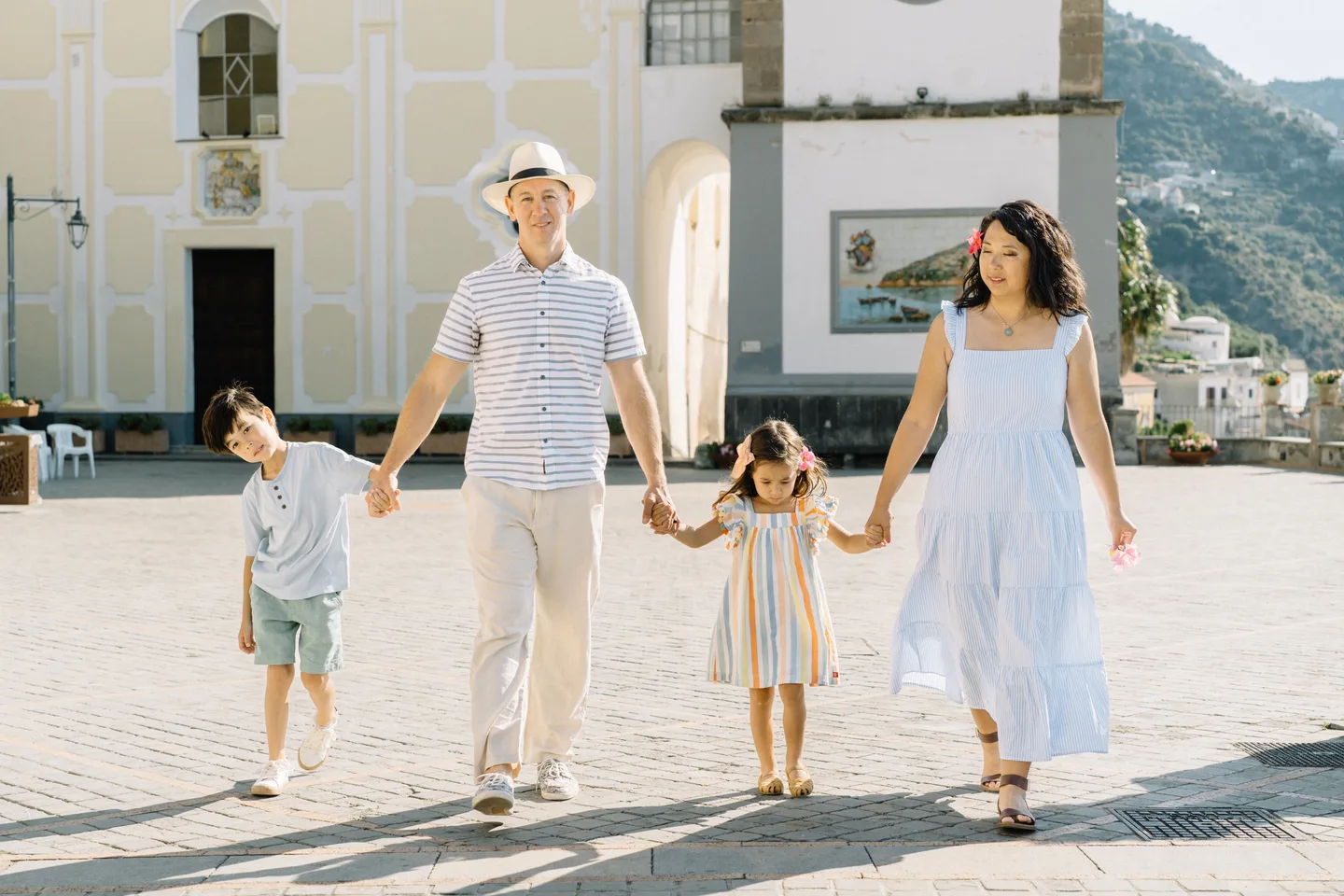 The family walking hand in hand across the piazza