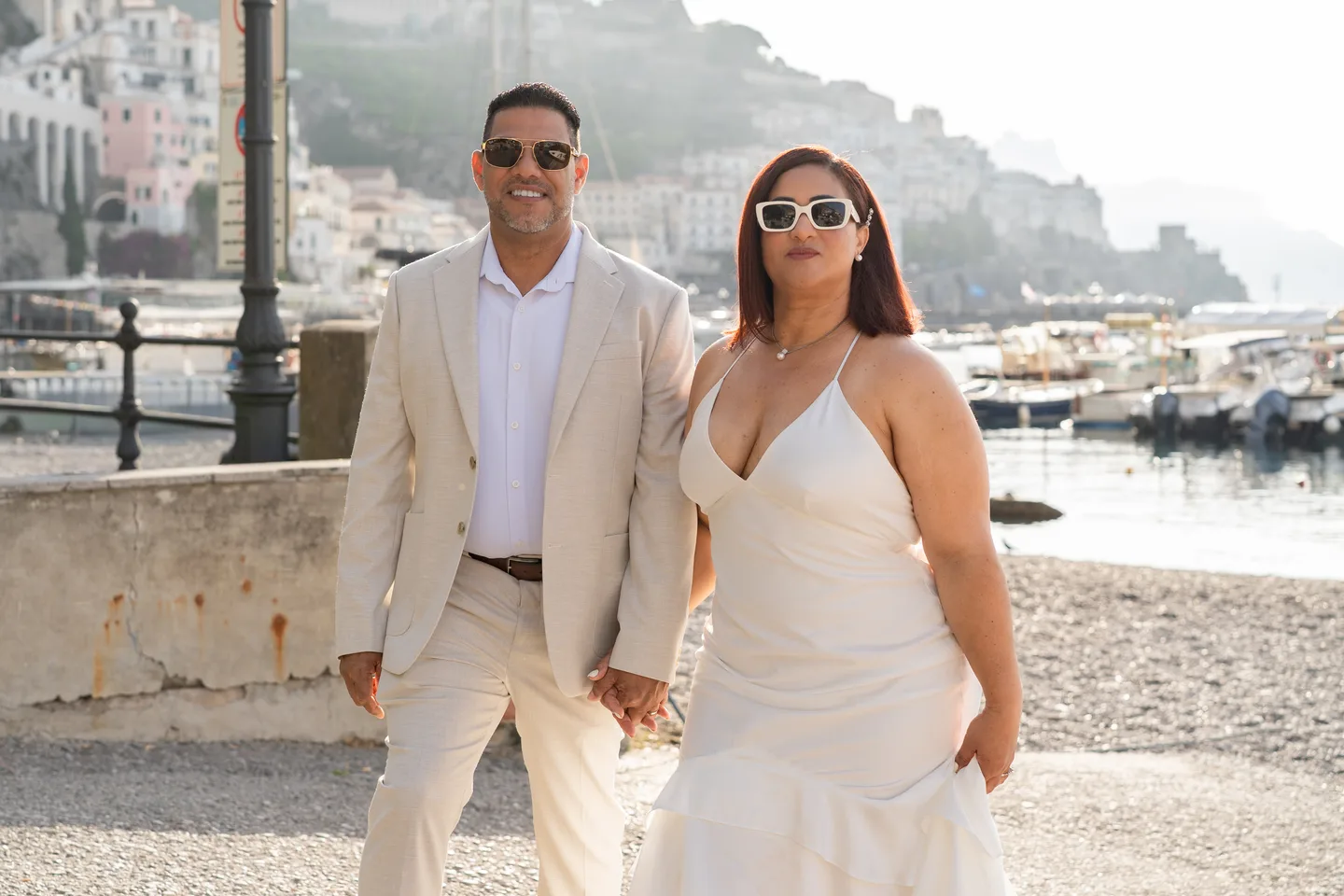 Nilsa and her husband beside the harbour in sunglasses