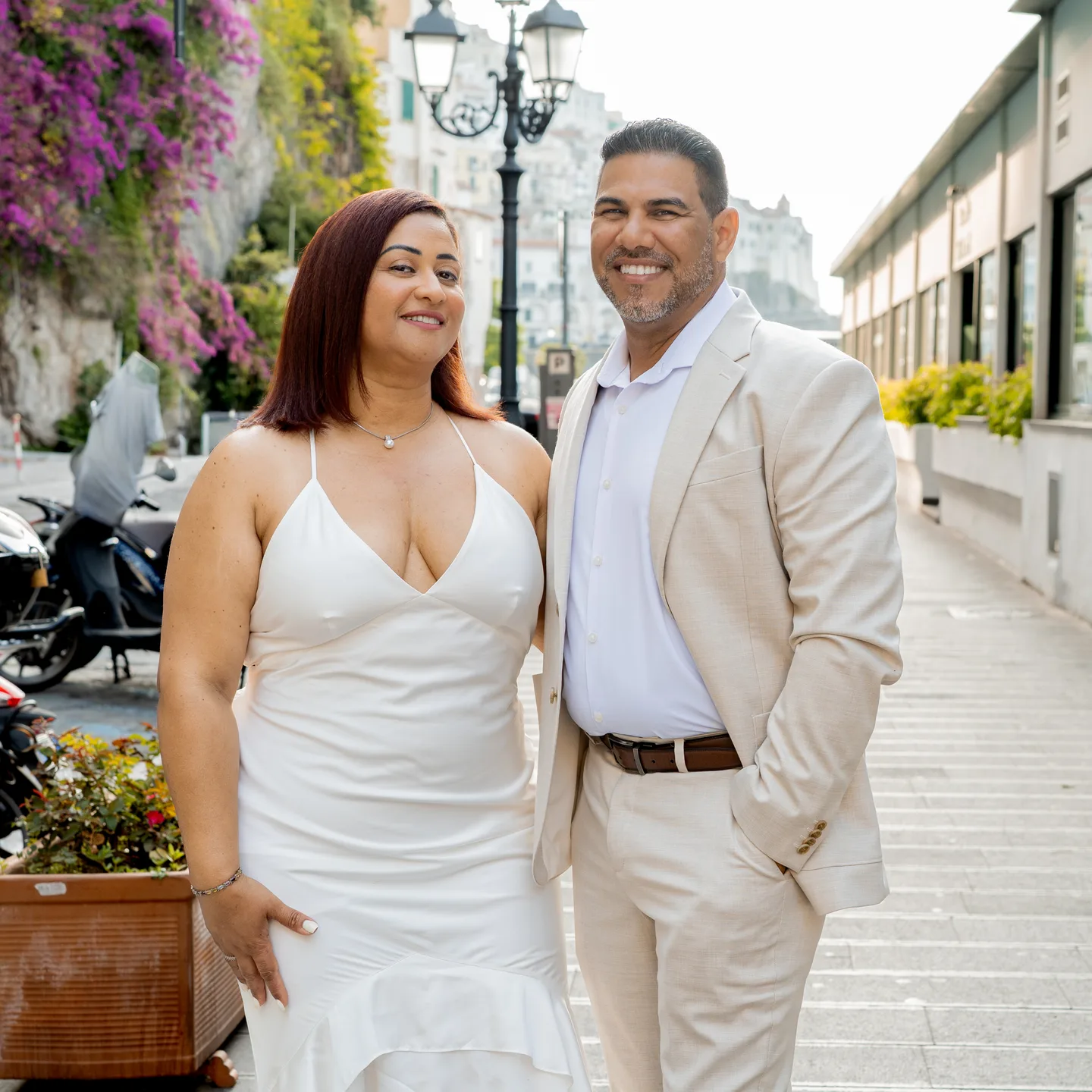 Nilsa and her husband smiling beneath the flowers