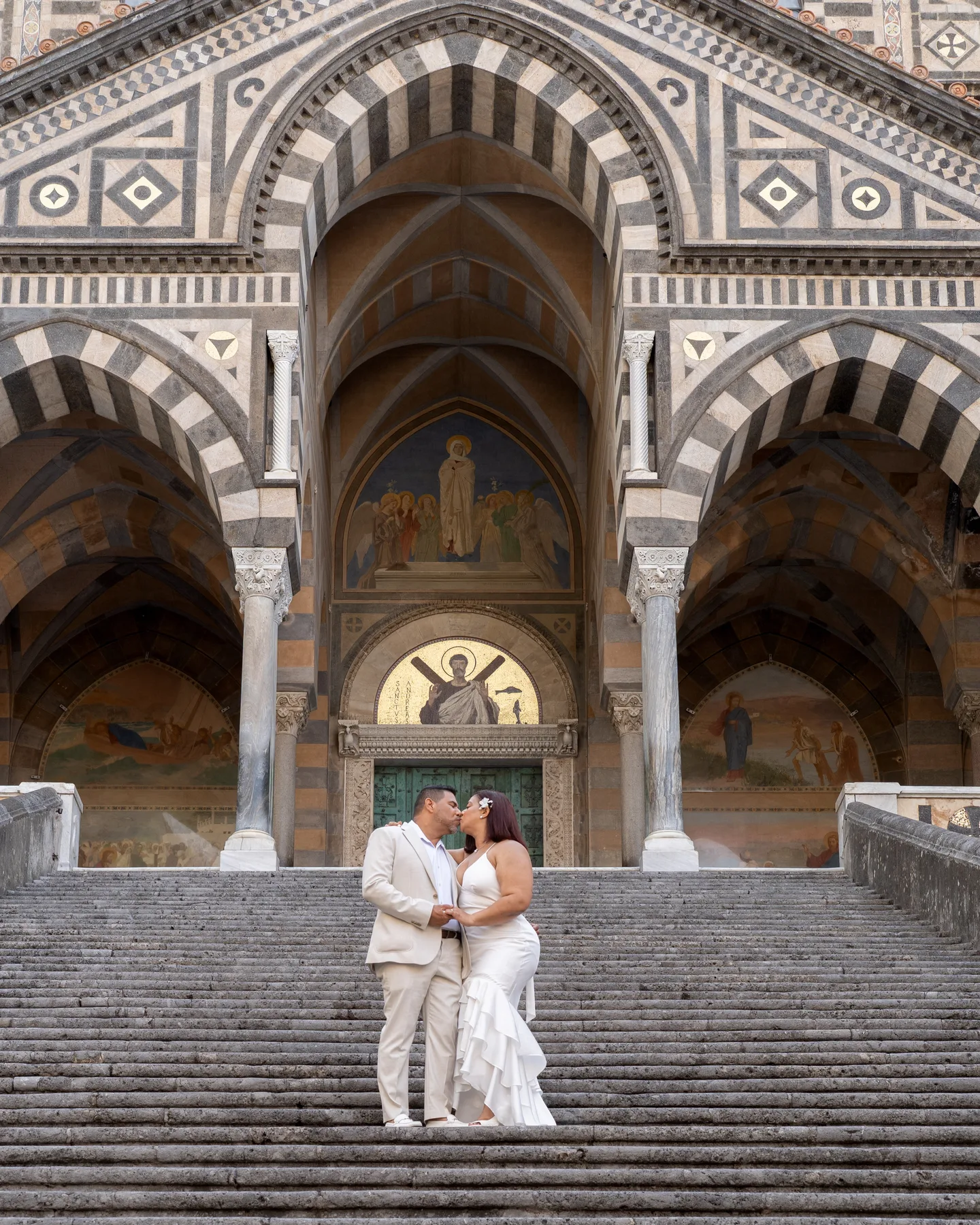 A wide view of the couple beneath the cathedral facade