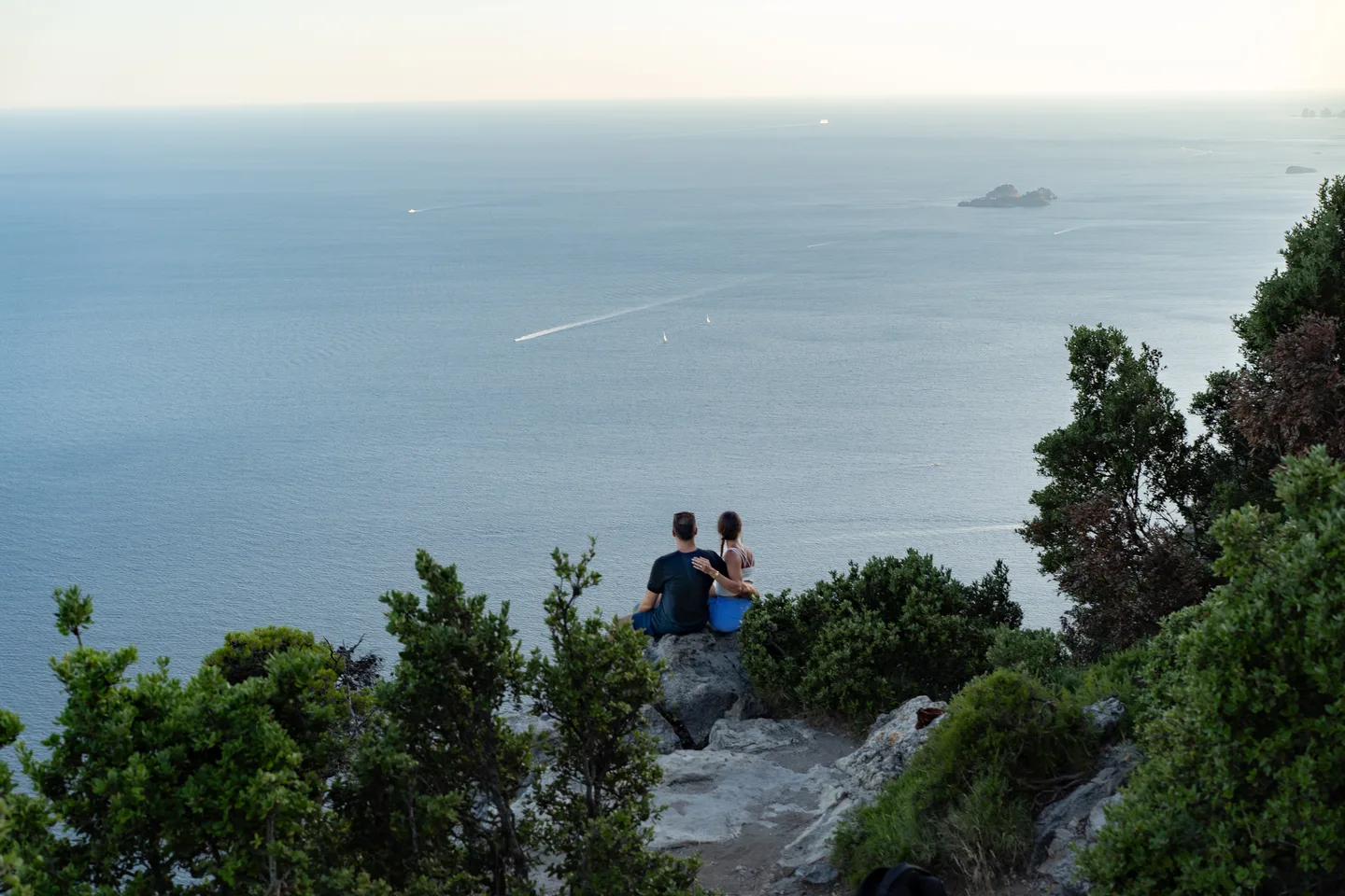 The couple framed by trees on the mountain trail