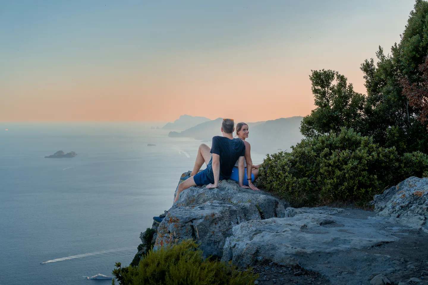 A wide view of the couple overlooking the sea