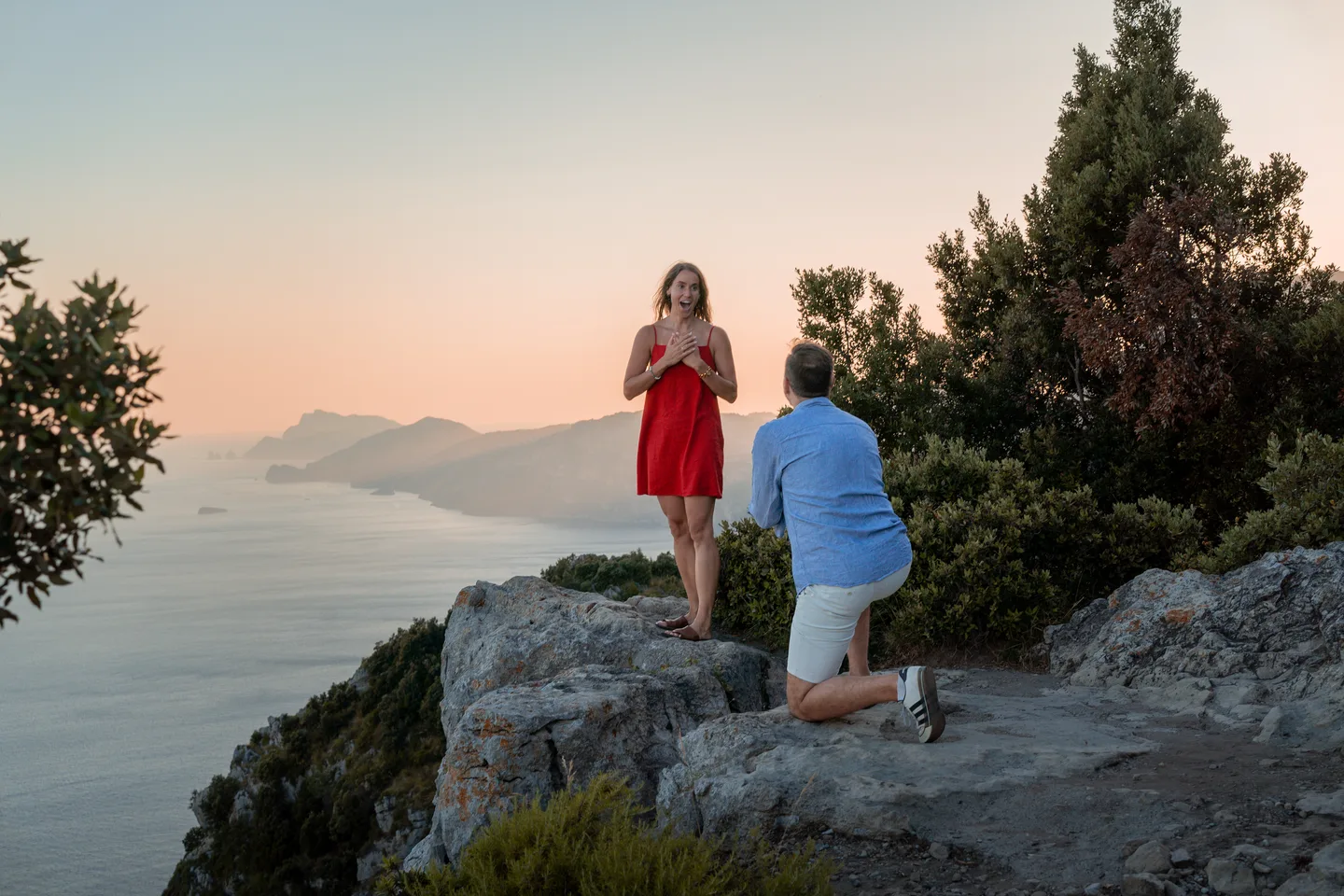 The proposal scene above the coast at golden hour
