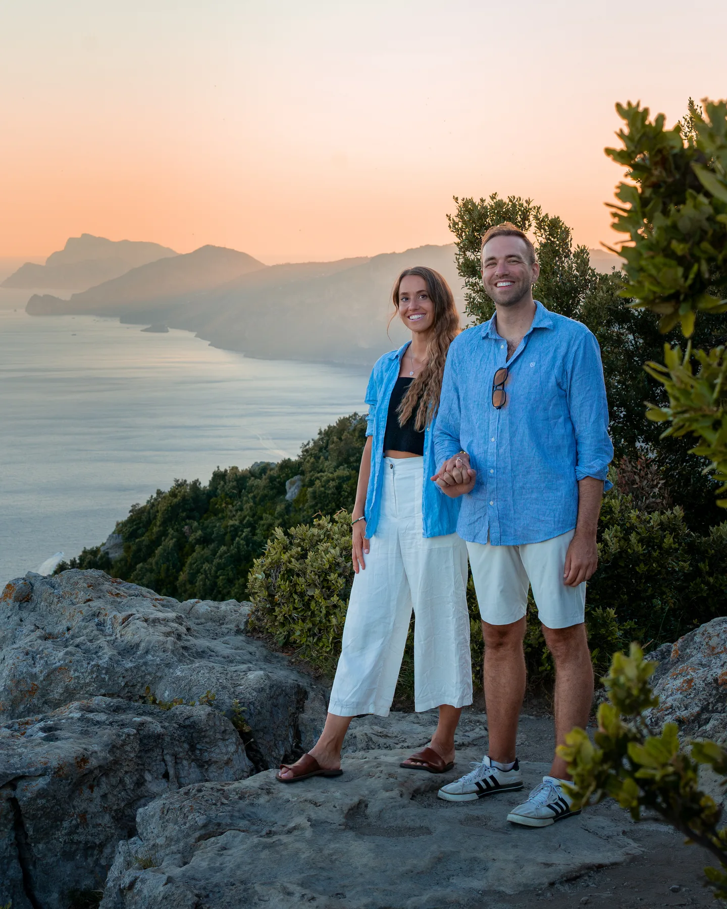 The couple standing together on the rocks