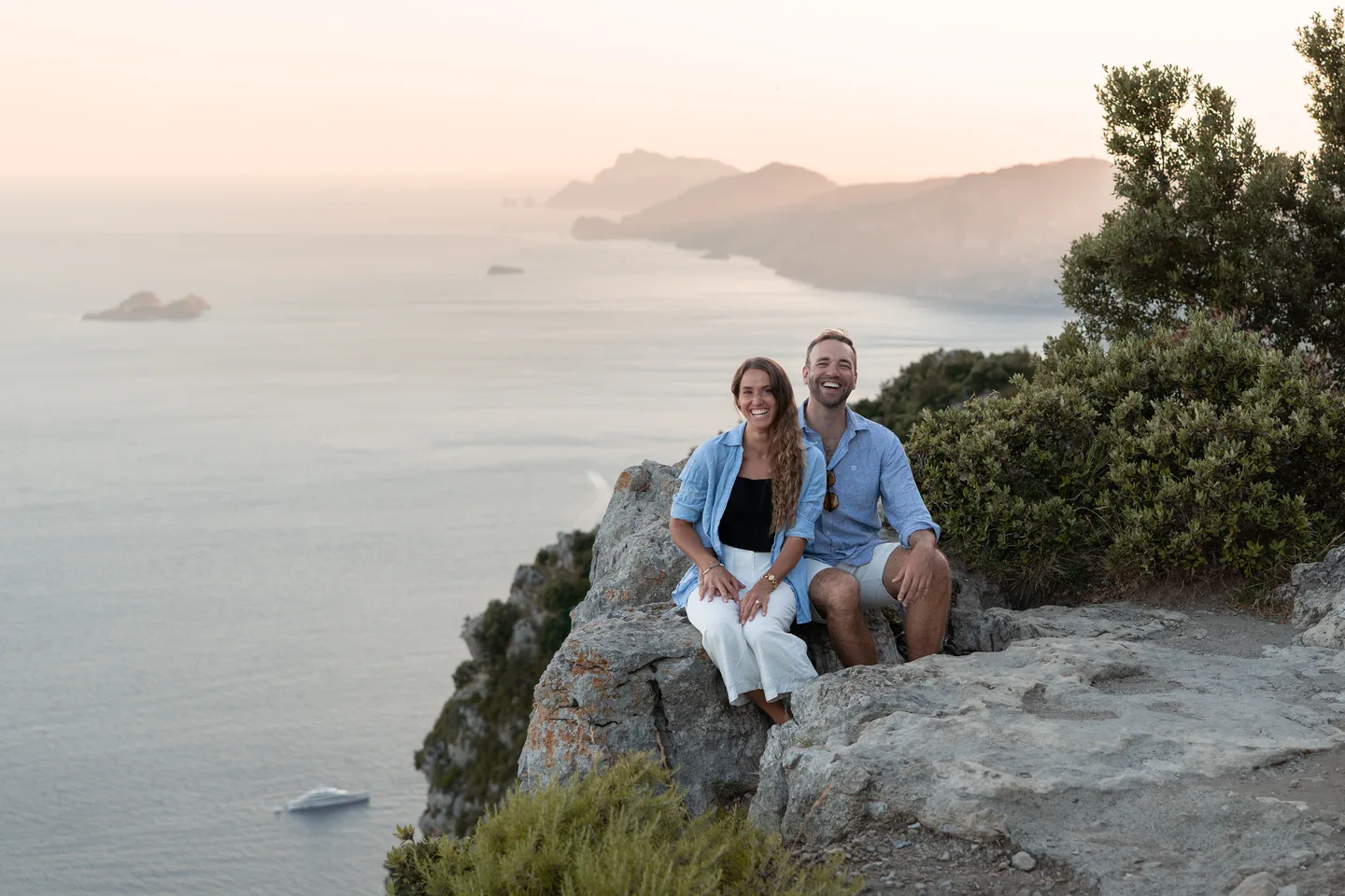 The couple sitting together above the sea