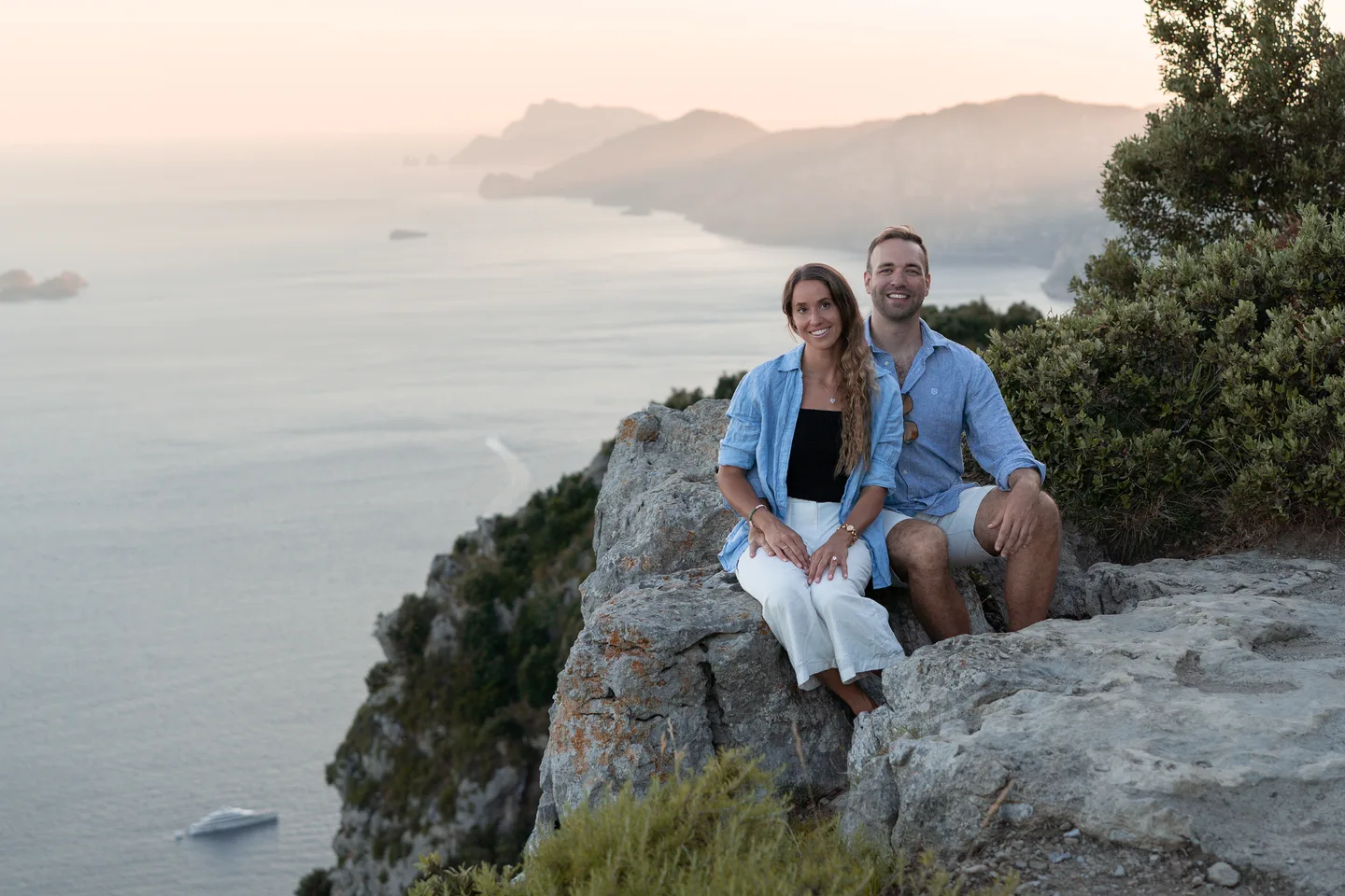 The couple seated at the mountain viewpoint