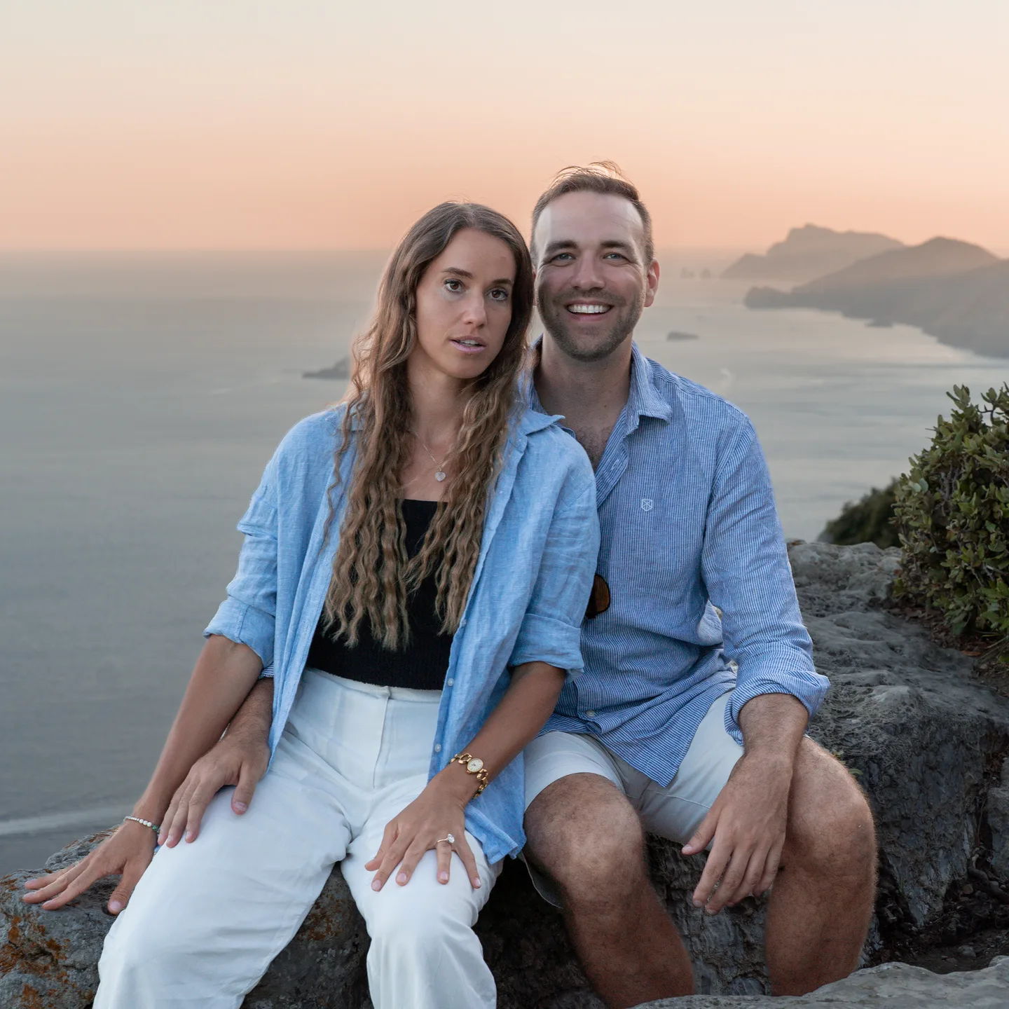 The couple together on the rocks at sunset