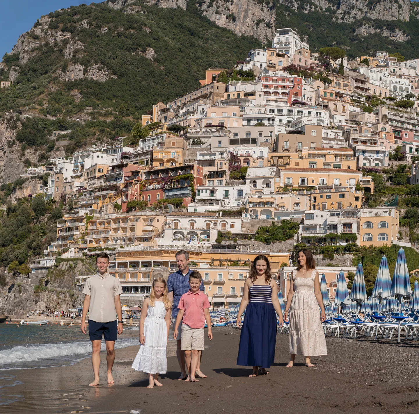 The family on the sand beneath the colourful town