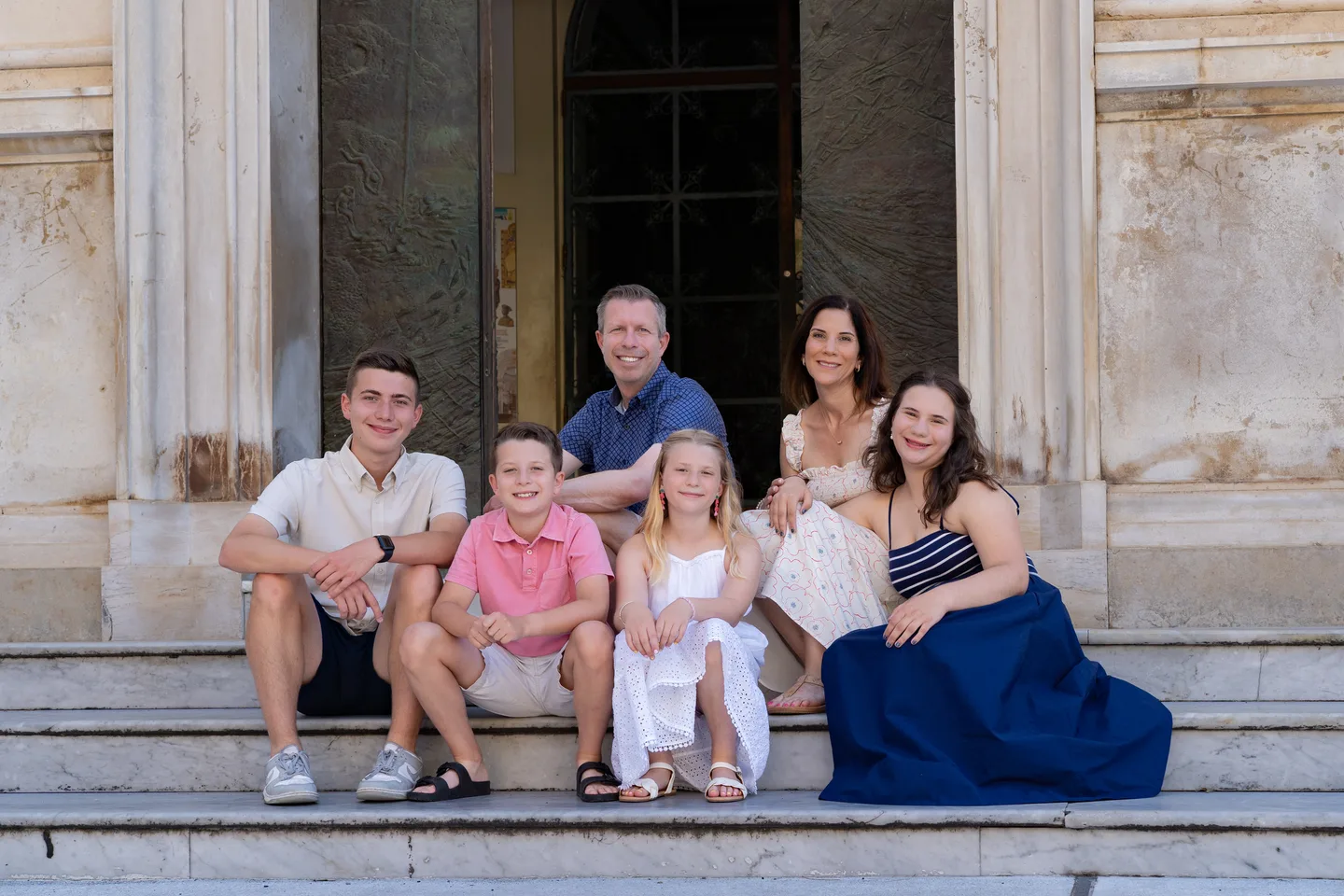 The family sitting together on the church steps
