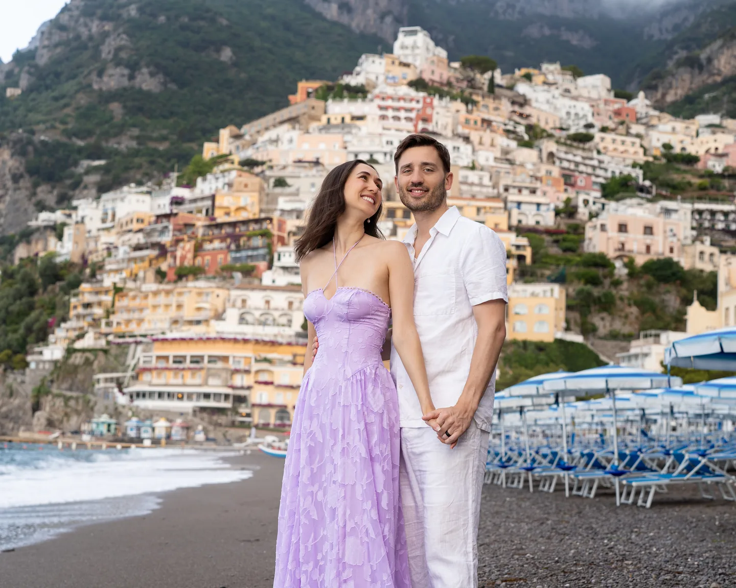 The couple with Positano rising behind them