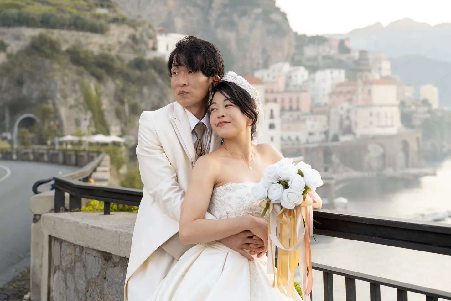 An embrace beside the railing with Atrani behind them