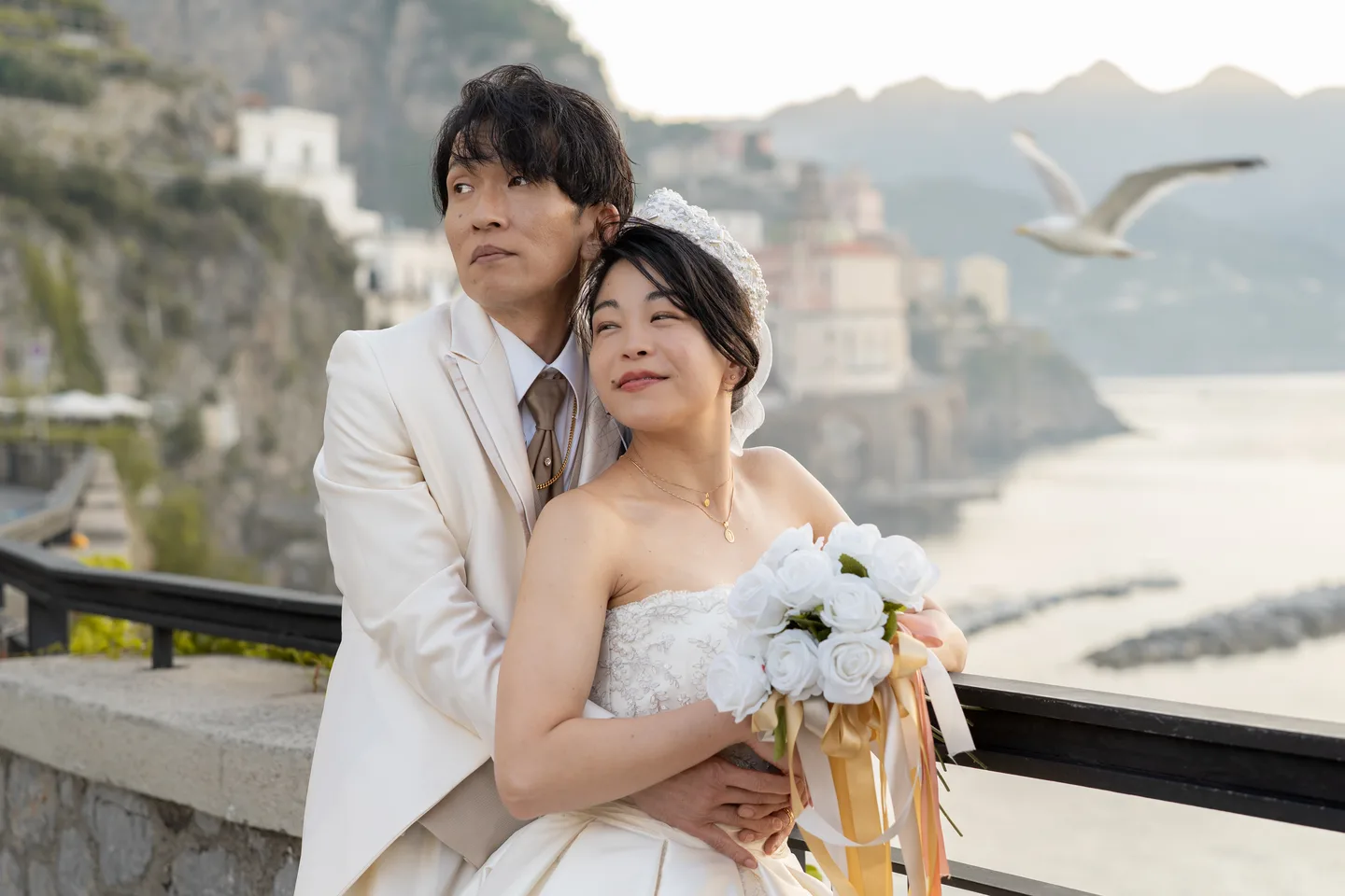 The couple looking across the coast as a bird passes