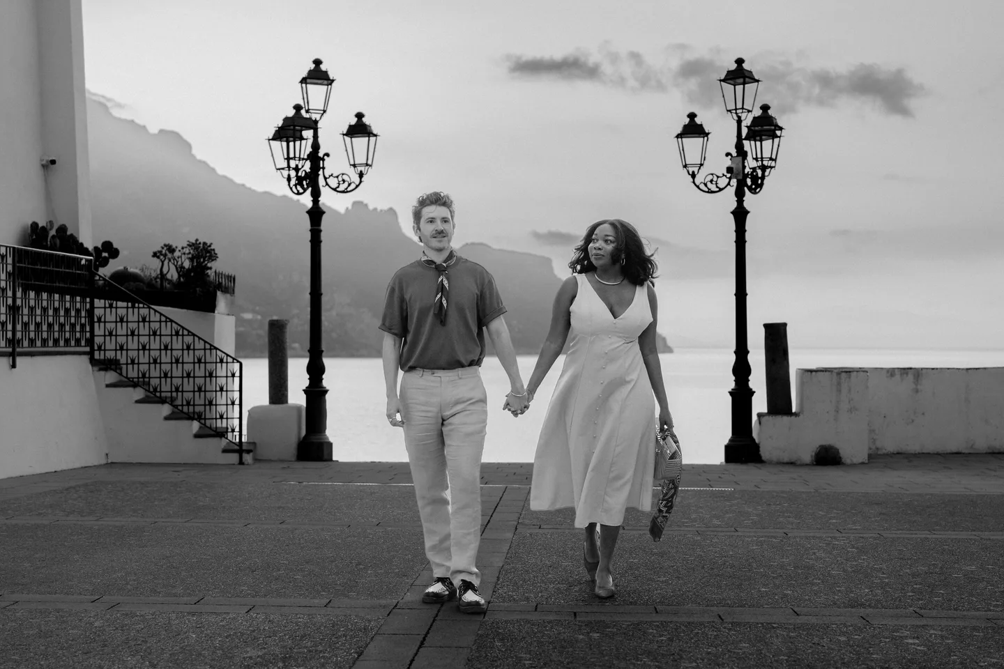 The couple walking towards the camera in black and white