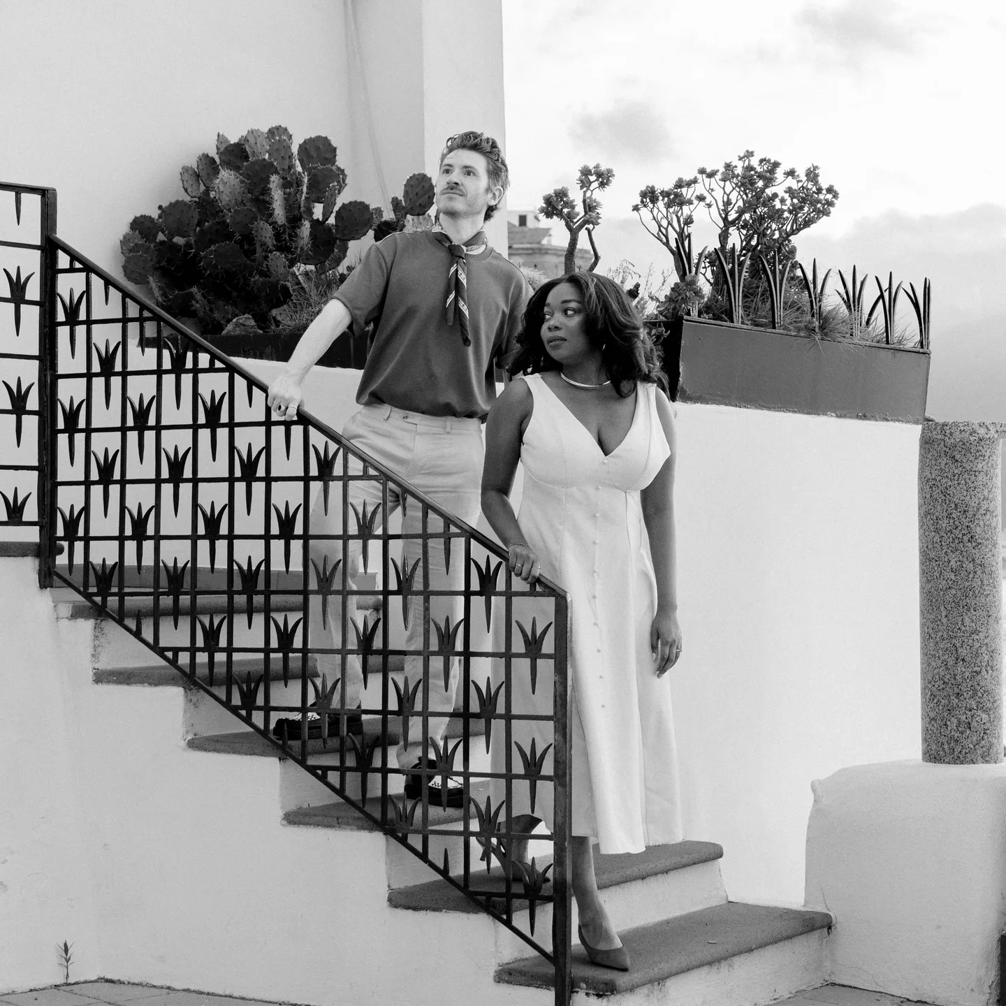 The couple descending the terrace steps in black and white