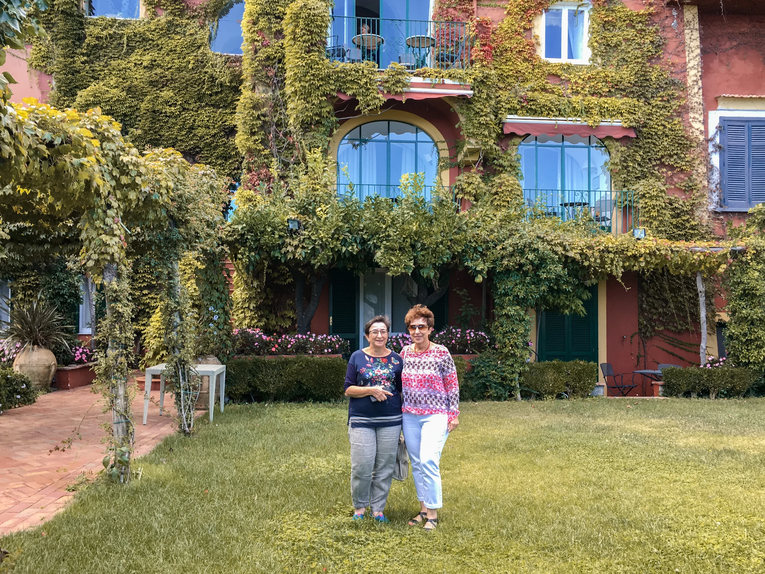 Guests at an ivy-covered villa garden on the coast